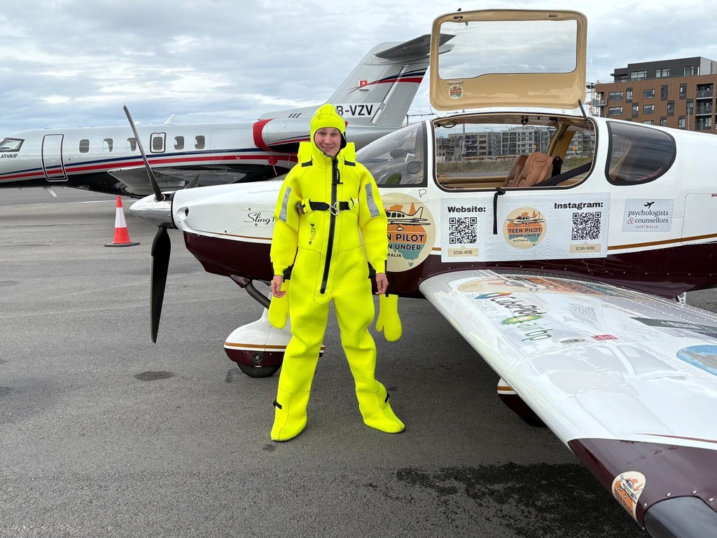 Byron in a survival suit standing next to VH-ZMD